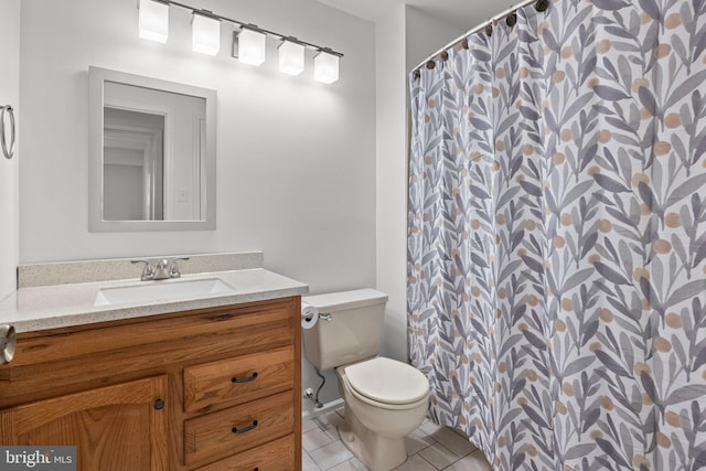 bathroom with toilet, vanity, and tile patterned floors