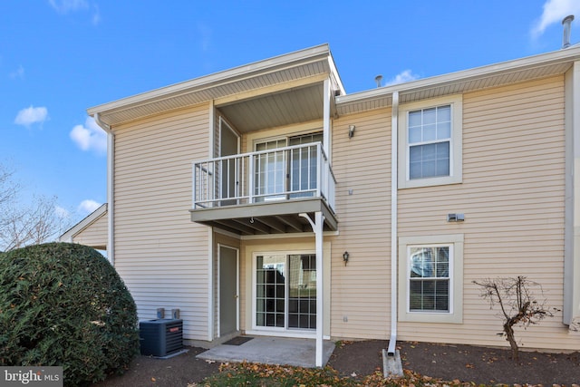 back of property with central AC and a balcony