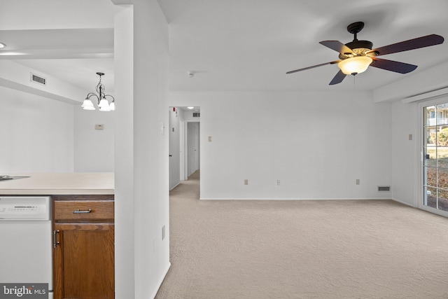 kitchen featuring pendant lighting, light colored carpet, white dishwasher, and ceiling fan with notable chandelier