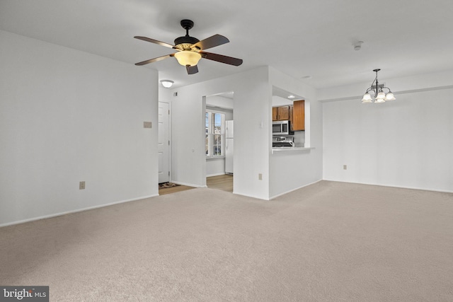 unfurnished living room with light carpet and ceiling fan with notable chandelier