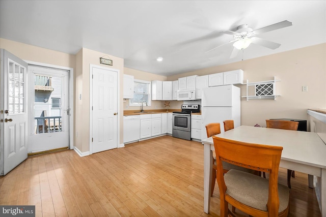 kitchen featuring white cabinetry, white appliances, sink, and light wood-type flooring