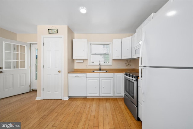 kitchen featuring white cabinets, white appliances, sink, and light wood-type flooring