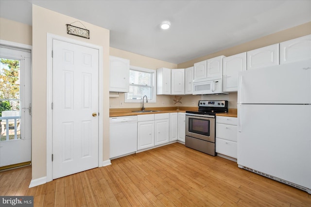 kitchen with white cabinetry, white appliances, light hardwood / wood-style floors, and plenty of natural light