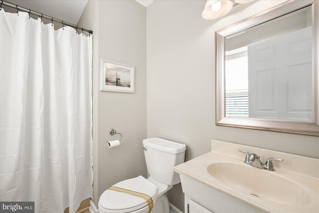 bathroom with toilet, vanity, and a shower with shower curtain