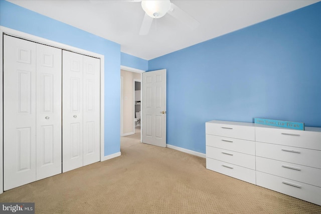 unfurnished bedroom featuring ceiling fan, a closet, and light colored carpet