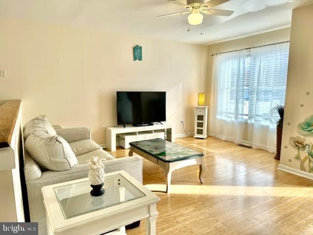 living room featuring light hardwood / wood-style floors and ceiling fan