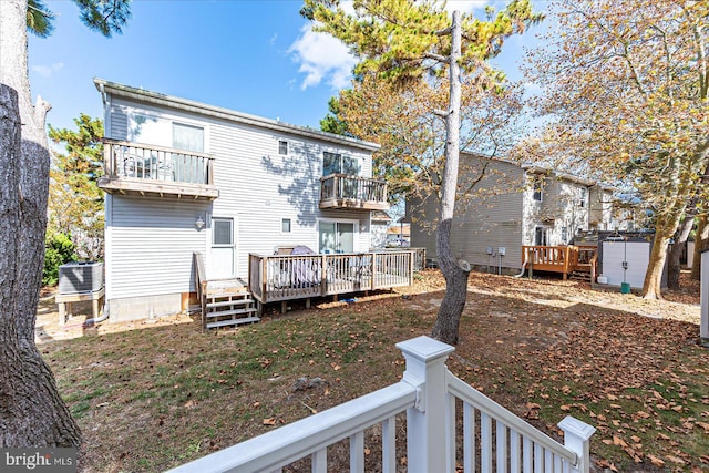 back of house with cooling unit, a balcony, and a deck