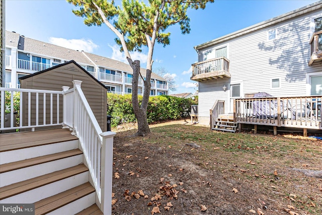 view of yard with a balcony and a deck