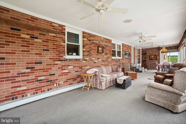 living room featuring crown molding, carpet flooring, baseboard heating, ceiling fan, and brick wall