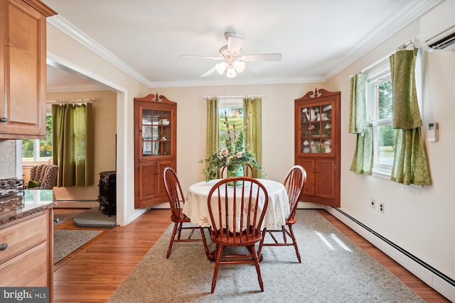 dining space with light hardwood / wood-style floors, a baseboard radiator, and a healthy amount of sunlight