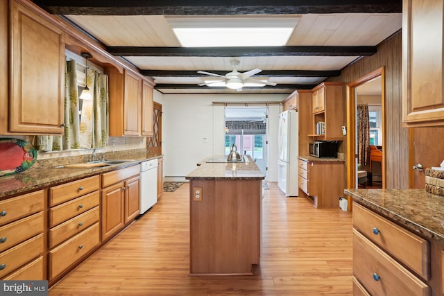 kitchen featuring light hardwood / wood-style flooring, a kitchen island, white appliances, and beam ceiling