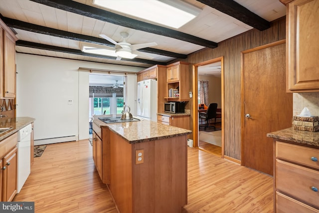 kitchen with appliances with stainless steel finishes, beam ceiling, and light stone countertops