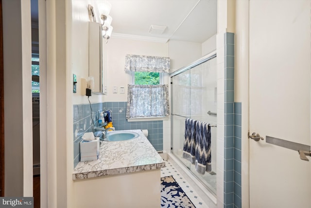 bathroom featuring tile walls, ornamental molding, vanity, and walk in shower