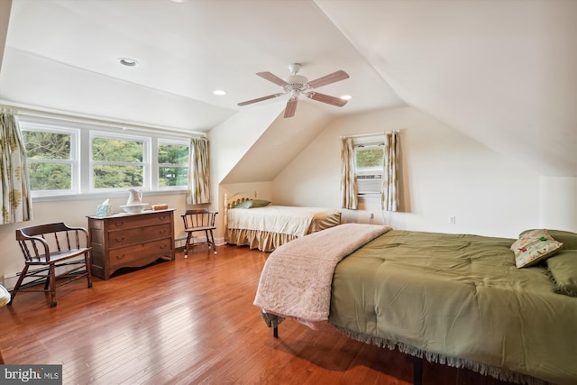 bedroom featuring multiple windows, vaulted ceiling, hardwood / wood-style flooring, and ceiling fan