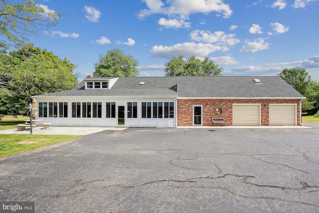 view of front of house featuring a garage and a sunroom