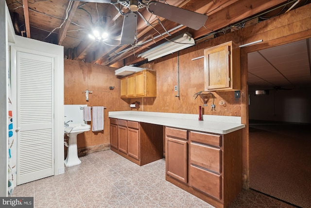 kitchen featuring wood walls and ceiling fan