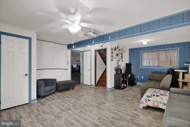 unfurnished living room featuring wooden walls, hardwood / wood-style floors, and ceiling fan