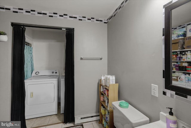 laundry room with light tile patterned flooring, a baseboard radiator, and washing machine and dryer