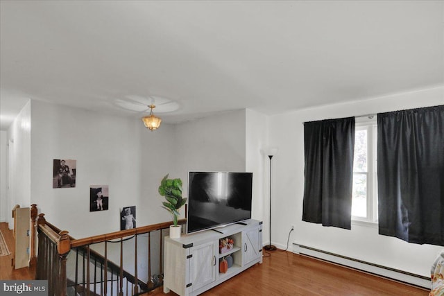 living room with wood-type flooring and a baseboard heating unit