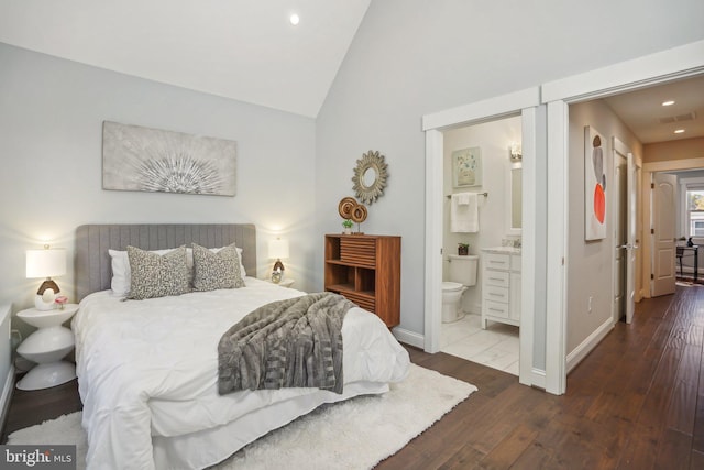 bedroom with dark hardwood / wood-style floors, ensuite bath, and vaulted ceiling