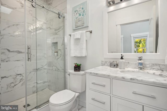 bathroom featuring vanity, toilet, and a shower with shower door