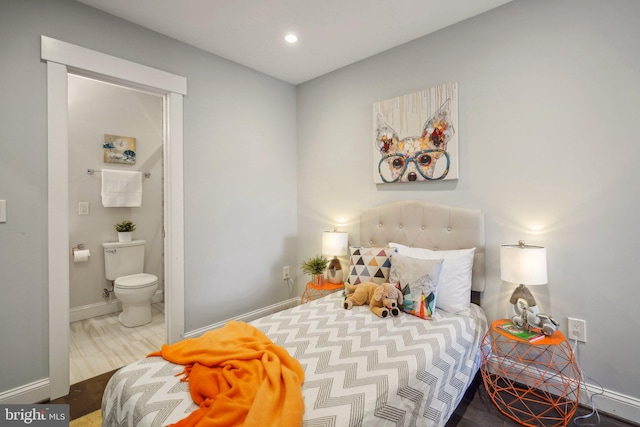 bedroom with hardwood / wood-style flooring and ensuite bathroom