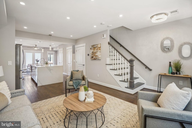 living room featuring dark wood-type flooring and sink