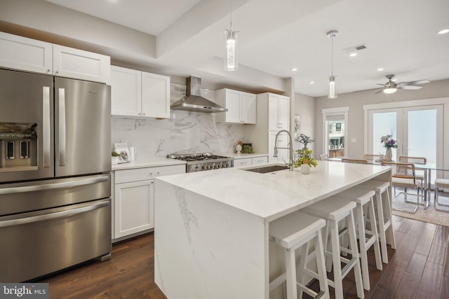 kitchen featuring stainless steel appliances, wall chimney exhaust hood, sink, and dark wood-type flooring