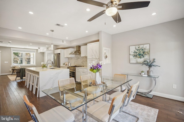 dining area featuring dark hardwood / wood-style floors, ceiling fan, and sink