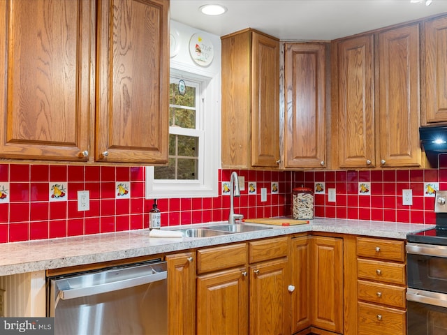 kitchen with decorative backsplash, appliances with stainless steel finishes, and sink