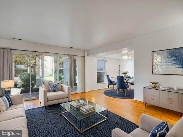 living room featuring hardwood / wood-style flooring and an inviting chandelier