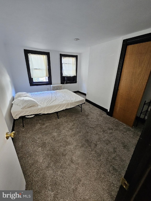 bedroom featuring radiator heating unit and dark carpet