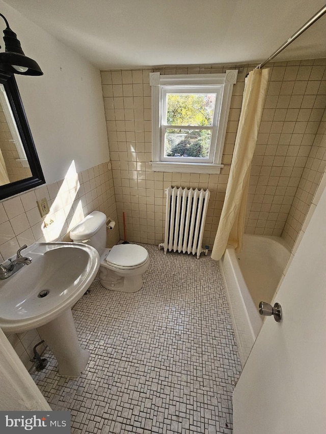 full bathroom with sink, shower / bathtub combination with curtain, radiator heating unit, toilet, and tile walls