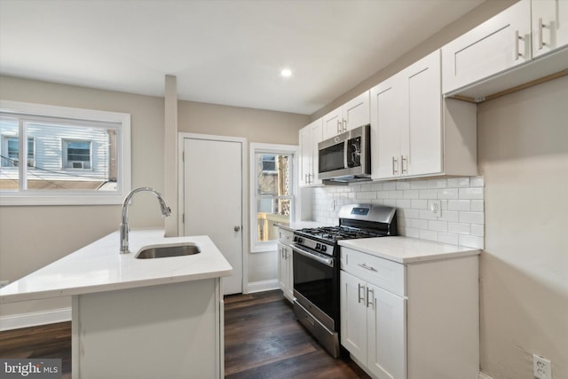 kitchen with stainless steel appliances, white cabinetry, sink, dark hardwood / wood-style floors, and decorative backsplash