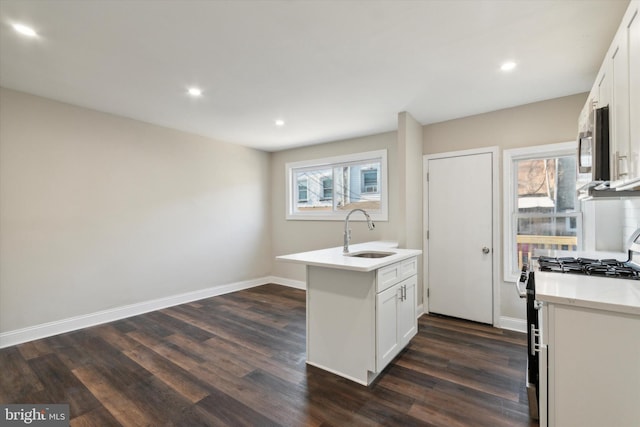 kitchen featuring white cabinetry, dark hardwood / wood-style floors, sink, kitchen peninsula, and gas range