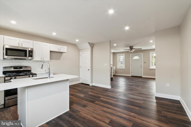 kitchen with dark hardwood / wood-style floors, sink, a kitchen island with sink, and appliances with stainless steel finishes