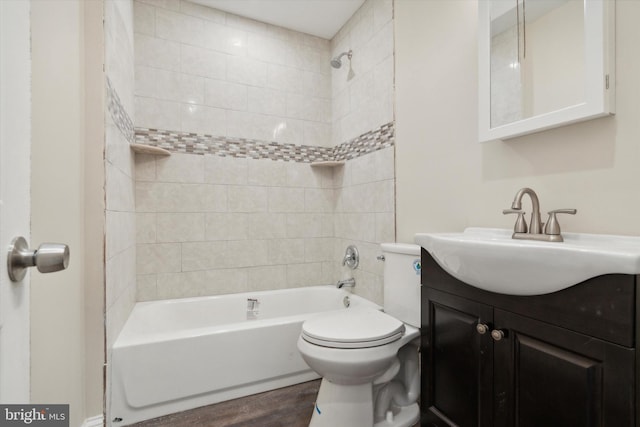 full bathroom featuring toilet, tiled shower / bath combo, vanity, and wood-type flooring