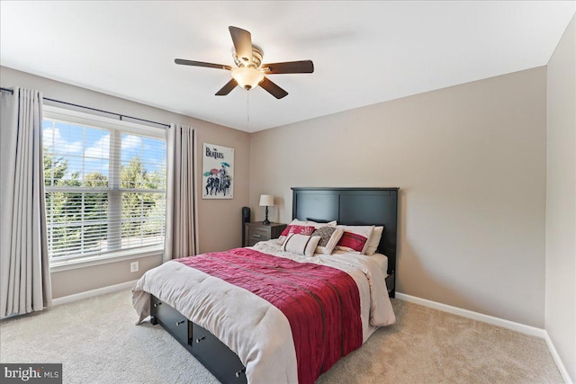 carpeted bedroom featuring multiple windows and ceiling fan