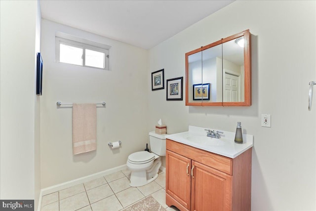 bathroom with toilet, vanity, and tile patterned floors