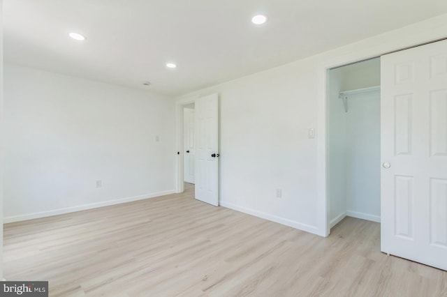 unfurnished bedroom featuring light hardwood / wood-style flooring and a closet