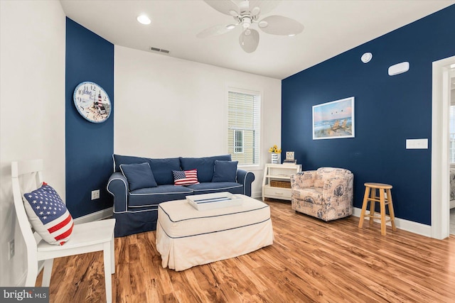 living room featuring wood-type flooring and ceiling fan