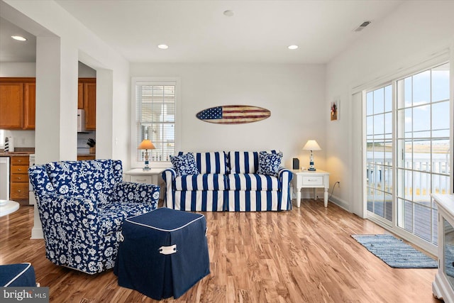 living room featuring a wealth of natural light and light hardwood / wood-style floors