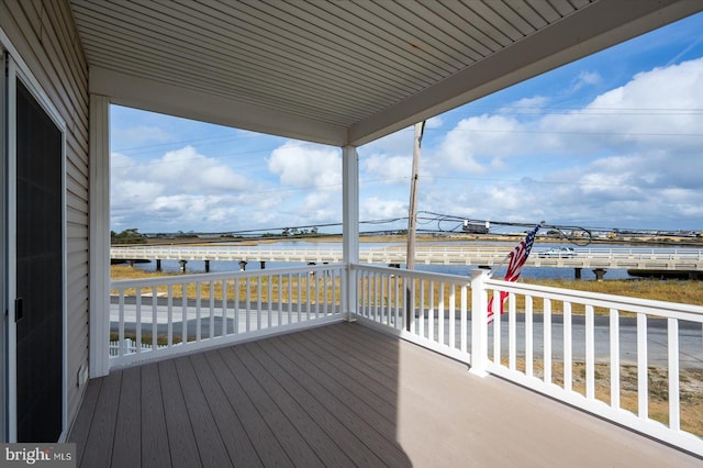 wooden terrace featuring a water view