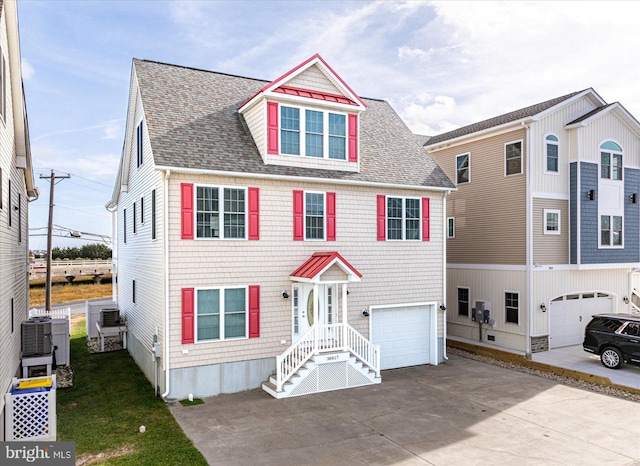 view of front of house with central air condition unit and a garage