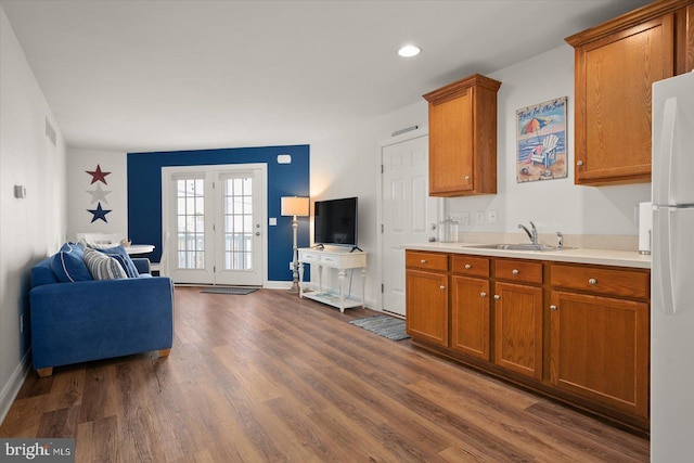 kitchen with dark hardwood / wood-style flooring, sink, and white fridge