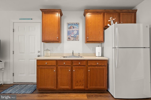 kitchen with dark wood-type flooring, white refrigerator, and sink