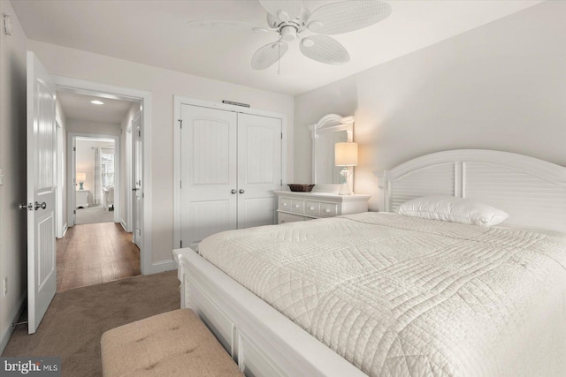 carpeted bedroom with ceiling fan and a closet