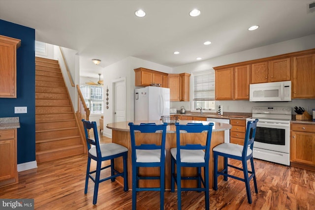 kitchen featuring a healthy amount of sunlight, white appliances, and a kitchen island