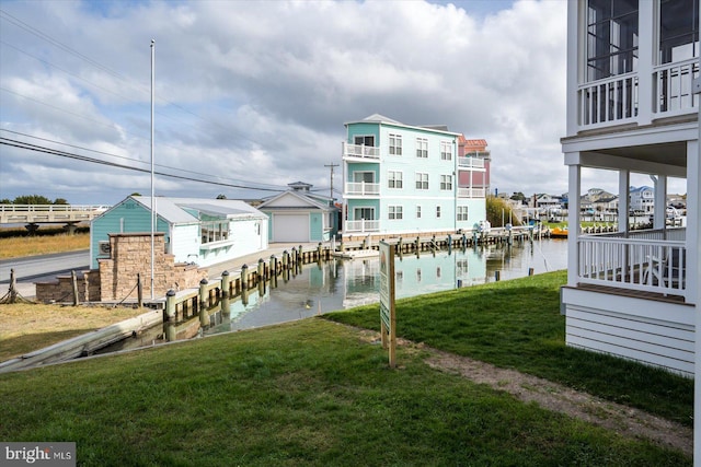 dock area with a lawn and a water view