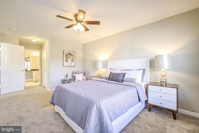 bedroom featuring ceiling fan, ensuite bath, and light carpet